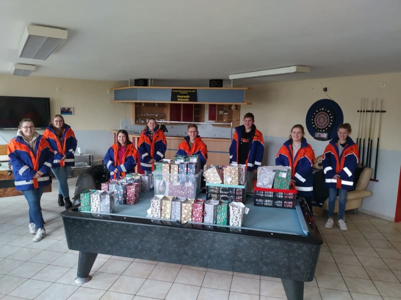 Die Jugendgruppe mit den gepackten Nikolauspaketen im Feuerwehrhaus
