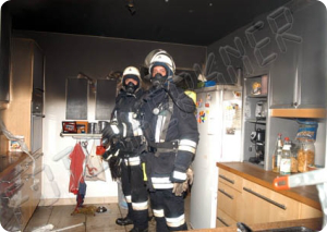 Zwei Atemschutzgeräteträger in einer ausgebrannten Küche