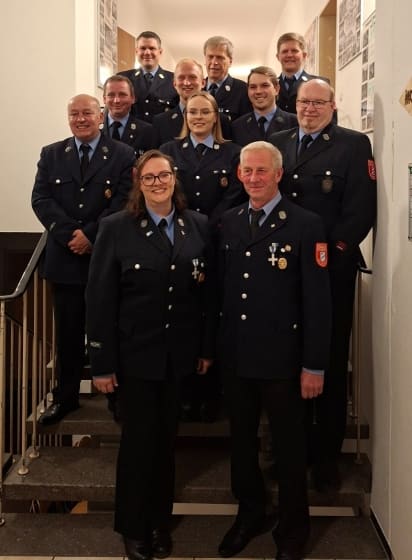Führung und Vorstandschaft der Feuerwehr Eicherloh in Uniform auf einer Treppe